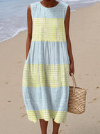 Sleeveless midi dress in blue and yellow gingham check with tiered colour block panels near the shore