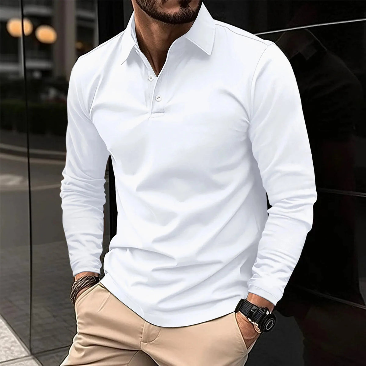 Front view of a man wearing a white long-sleeve polo shirt with white buttons and a classic collar, paired with beige pants