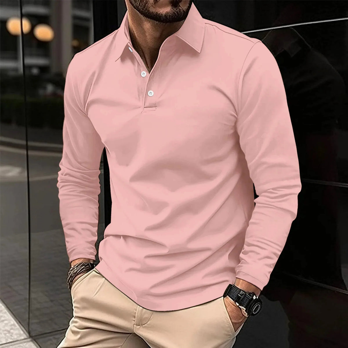 Soft pink long-sleeve polo shirt with a classic collar and white button placket, styled with beige pants