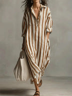 Full-length shot of a woman wearing a red striped maxi shirt dress with hair blowing in the wind