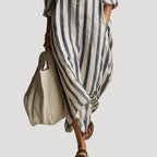Close-up of the flowing hemline and side pocket detail on the blue and white striped maxi dress