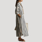 Side profile view showing the relaxed silhouette and side slit of the blue striped linen shirt dress
