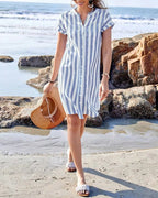 Full length view of the striped midi dress worn with woven sandals and a straw sun hat