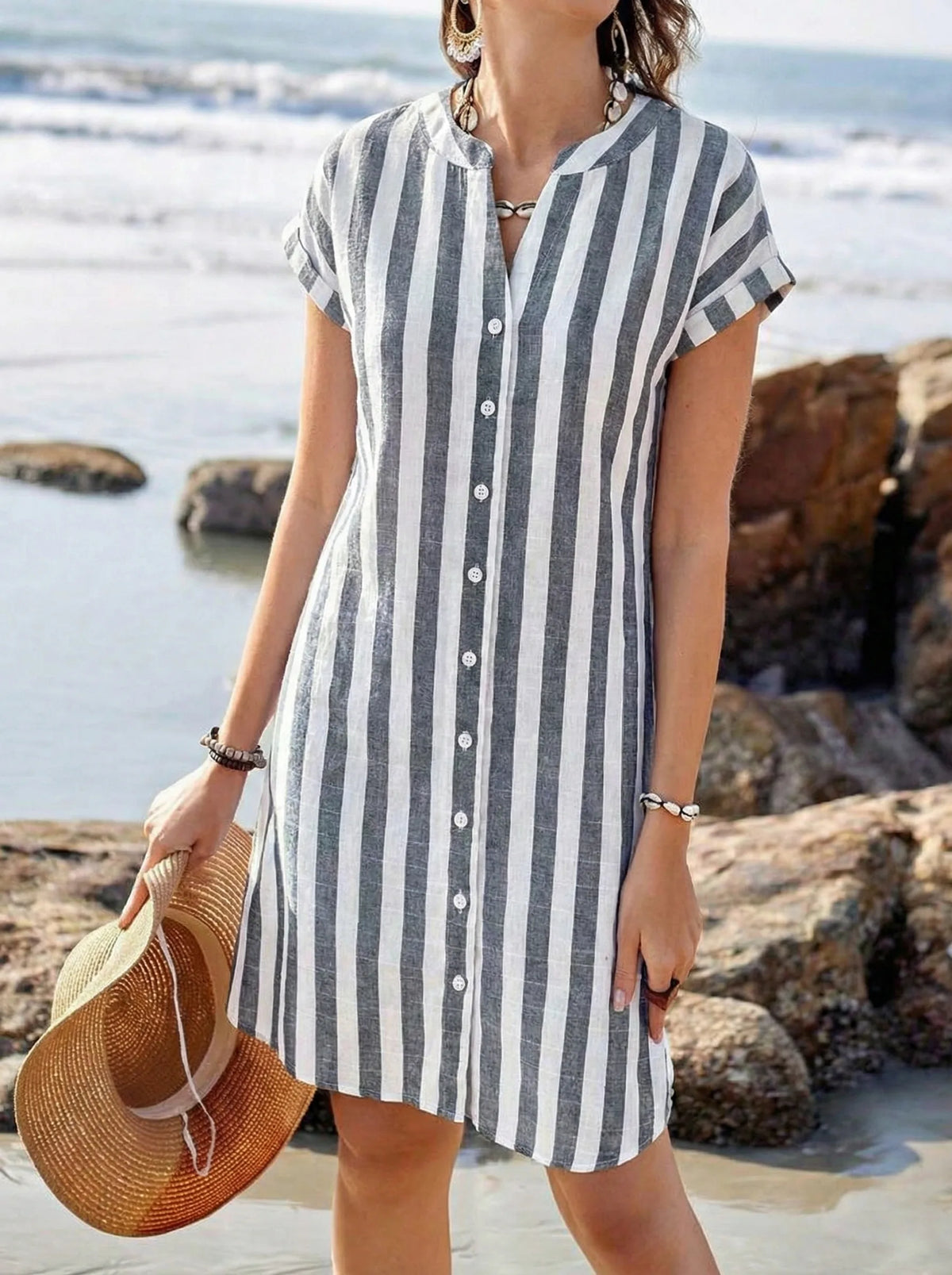 Close-up of the grey and white striped fabric with button detailing against a rocky beach backdrop