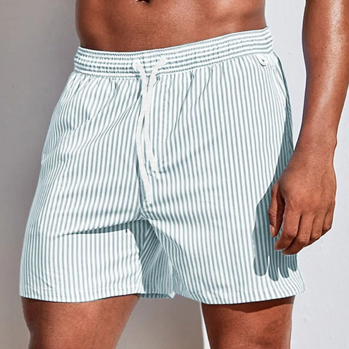 Front view of sage green and white striped boardshorts with elastic drawstring waistband