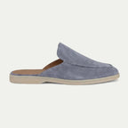 Side profile of a powder blue suede slip-on mule with open heel and tonal topstitched detailing