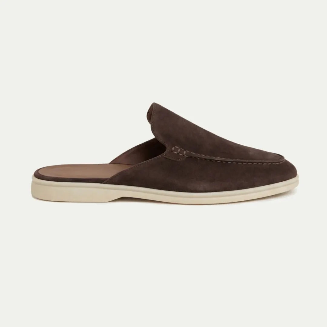 Side view of a dark brown suede backless loafer mule with cream sole and classic stitched vamp