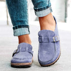 Dusty purple suede clog-style loafers with silver buckle, side profile showing the moulded footbed