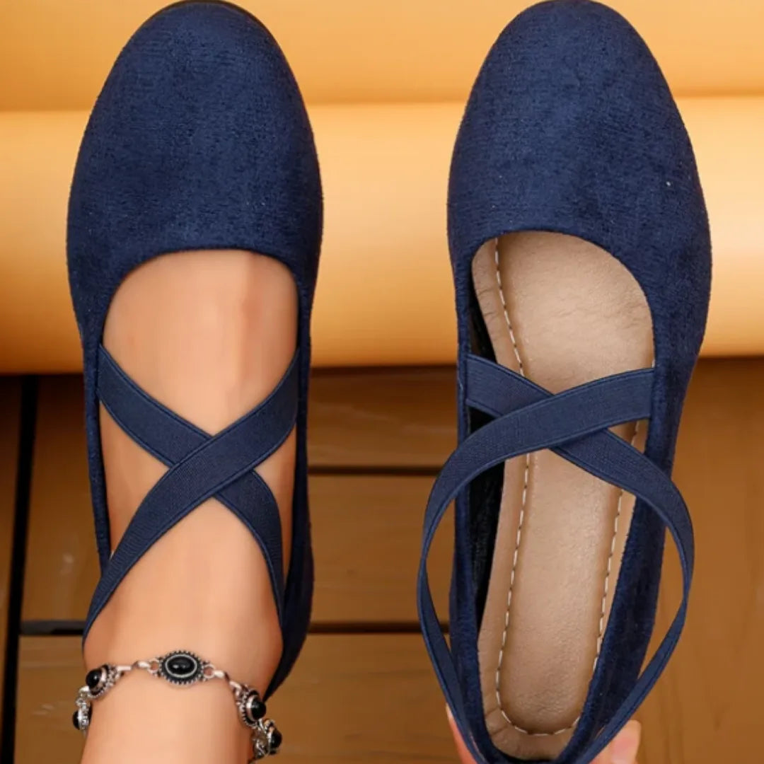 Top-down comparison of navy suede flats showing the outer crisscross strap and the inner leather-lined footbed