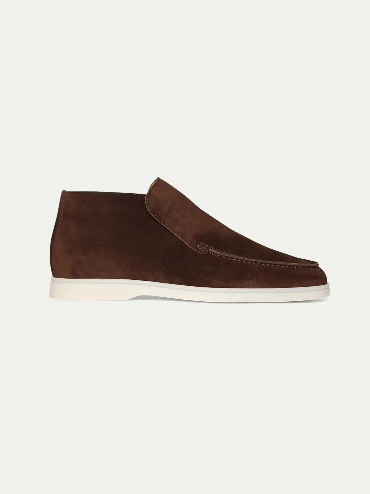 Side profile of a brown suede ankle boot with moc-toe stitching and a clean white rubber sole