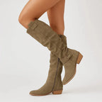 Olive green suede knee-high slouch boot with tab pull and low block heel, worn on model