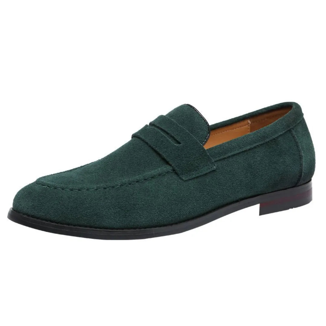 Dark green suede penny loafer photographed from a side angle on a white background