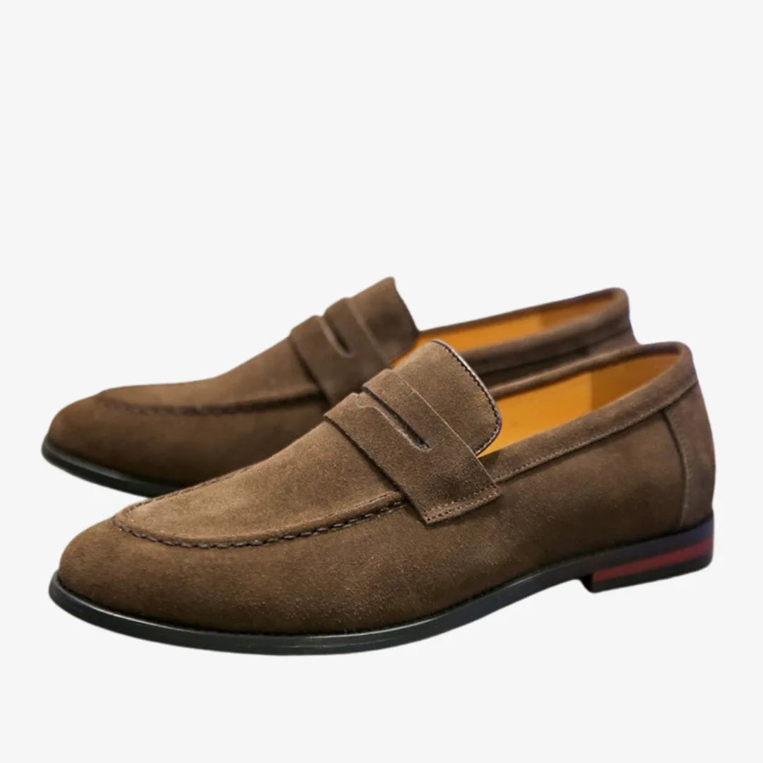 Pair of brown suede penny loafers placed side by side, angled to show the heel and sole