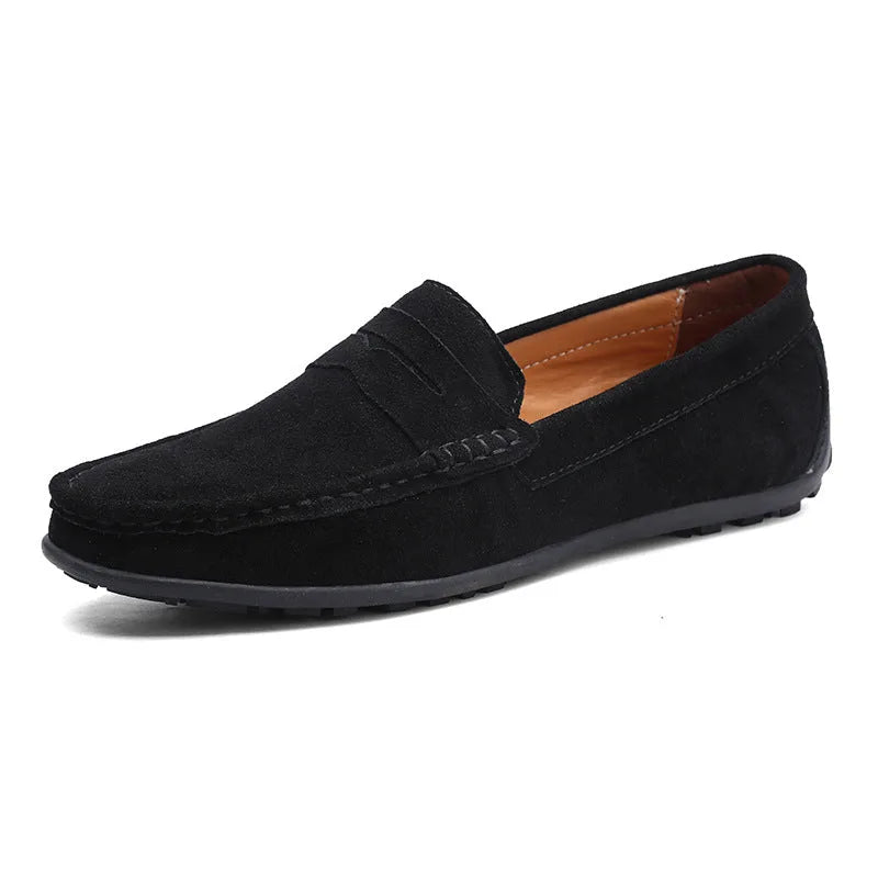 Angled side view of black suede penny loafer showing tan leather lining and moulded rubber sole