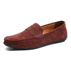 Rust brown suede penny loafer with visible stitched apron toe and flexible driving sole