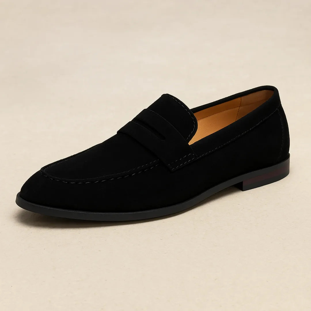 Single black suede penny loafer with a burgundy heel stripe accent, shown in side profile