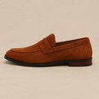 Single rust brown suede penny loafer with tan interior and burgundy heel detail, shown in side profile