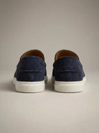 Rear view of navy suede slip-on loafers showing the heel seam, white outsole and low-profile silhouette