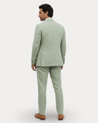 Back view of the sage green linen suit showing tailored blazer fit and trouser drape