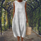 White sleeveless midi dress with subtle tone-on-tone dot pattern, falling in a relaxed, rounded silhouette.