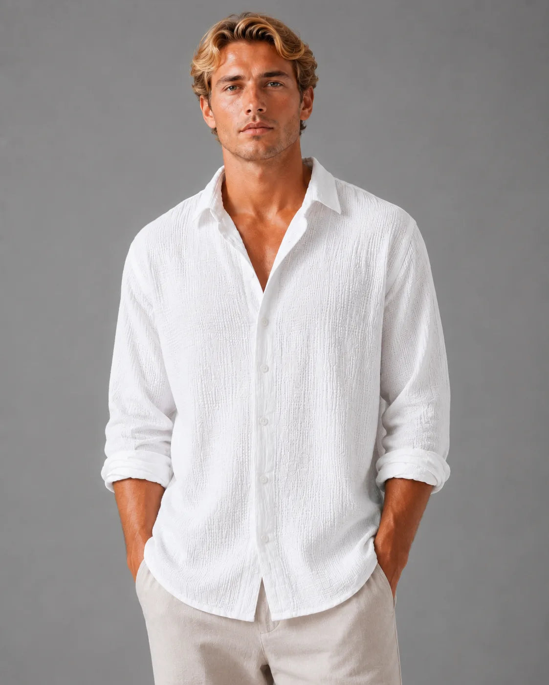 Man wearing a white textured cotton shirt with open collar, relaxed fit, hands in pockets