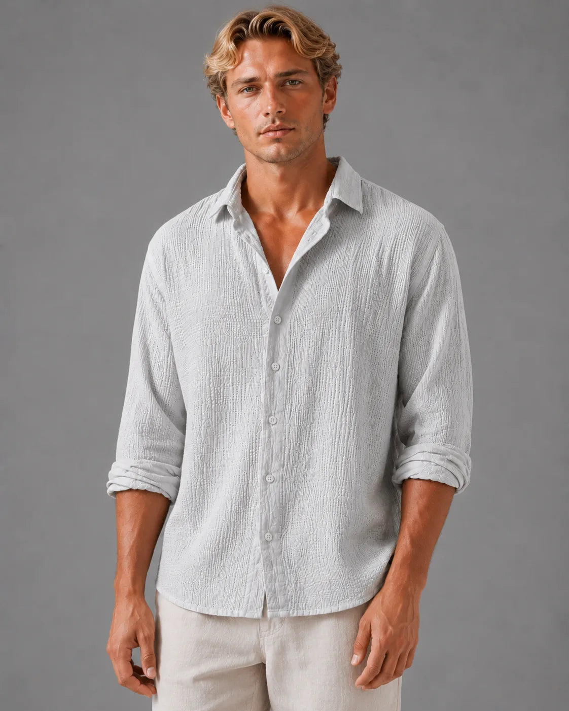 Man wearing a light grey textured cotton shirt, front view, buttoned with rolled sleeves