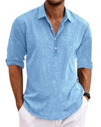 Close-up front view of a man wearing a light blue textured popover shirt with collar and three-button placket, paired with white pants