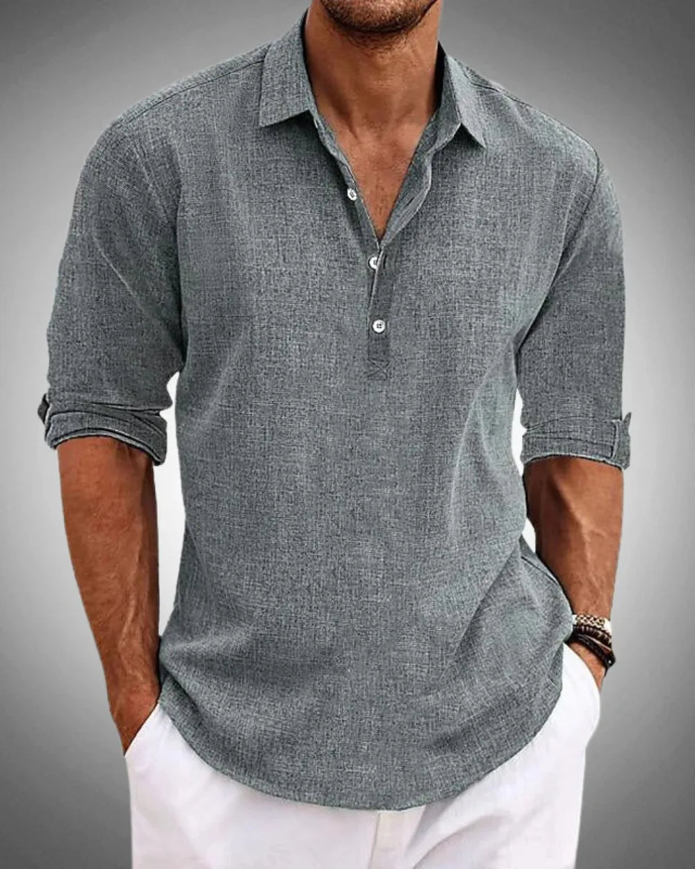 Front detail of a grey textured popover shirt with collar, button placket and rolled-up sleeves on a male model