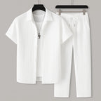 White textured short-sleeve shirt and drawstring trousers set shown on hangers with a layered white tee and pendant