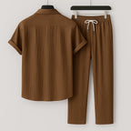 Back view of the brown ribbed short-sleeve shirt and matching trousers, highlighting the collar and rolled cuffs