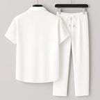 Back view of the white ribbed shirt and trousers set on hangers, showing the point collar and drawstring waist detail