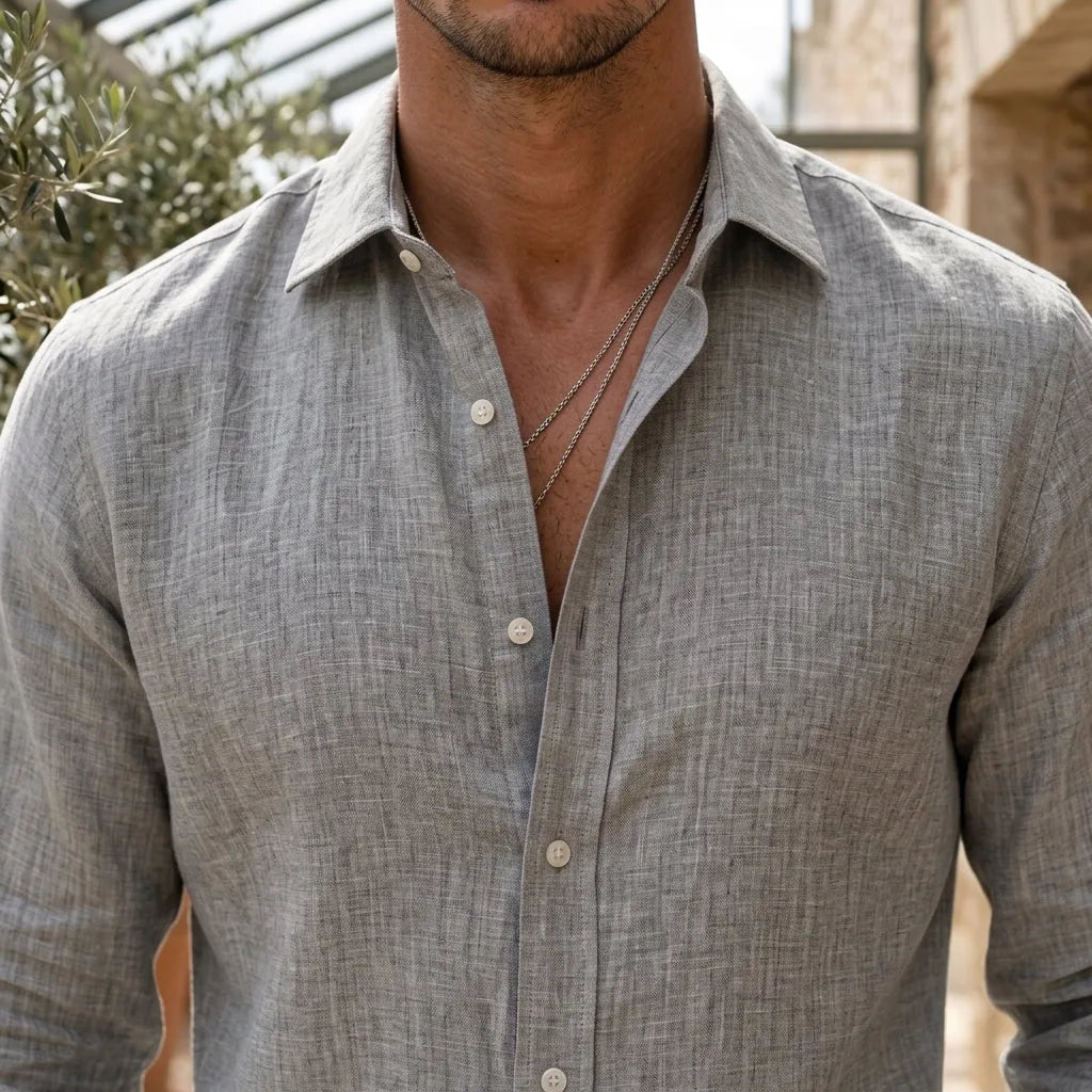 Close-up of the grey woven shirt fabric and mother-of-pearl style buttons at the open collar