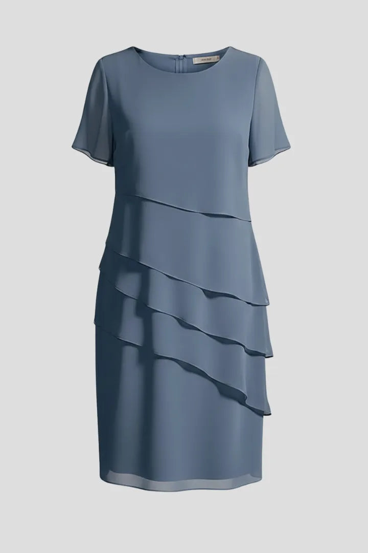 Blue layered chiffon dress on a mannequin, round neckline, short sleeves and asymmetric tiered skirt panels