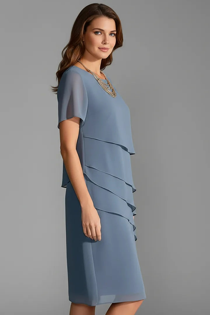 Side profile view of the blue tiered chiffon dress showing the sheer short sleeve and flowing side seam