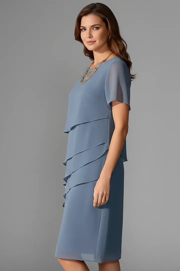 Three-quarter side view of the blue tiered dress highlighting the layered, asymmetric skirt panels