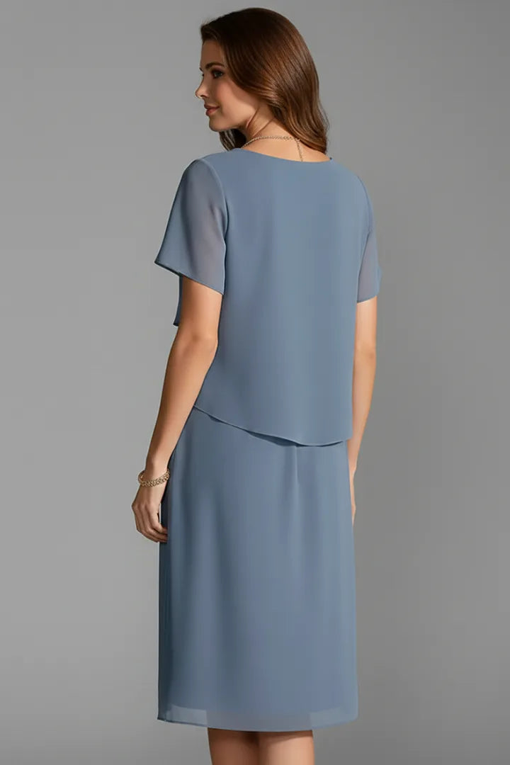 Back view of the blue tiered chiffon dress showing the round neckline and straight back hem