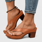 Side profile of brown block-heel sandals showing the criss-cross toe-post strap and platform sole