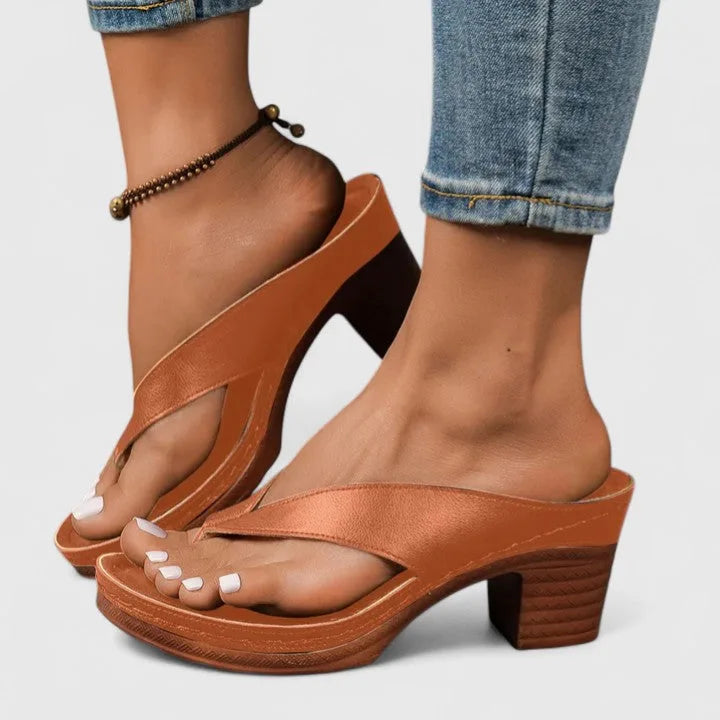 Side profile of brown block-heel sandals showing the criss-cross toe-post strap and platform sole