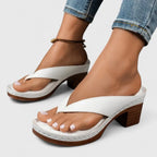 White toe-post block-heel sandal worn on foot, styled with cuffed denim jeans