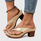 Gold-tone toe-post sandal shown side-on, worn with rolled-up jeans and a beaded anklet