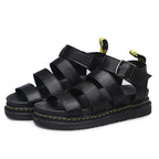 Pair of black platform sandals arranged together showing the full triple strap design and buckle detail