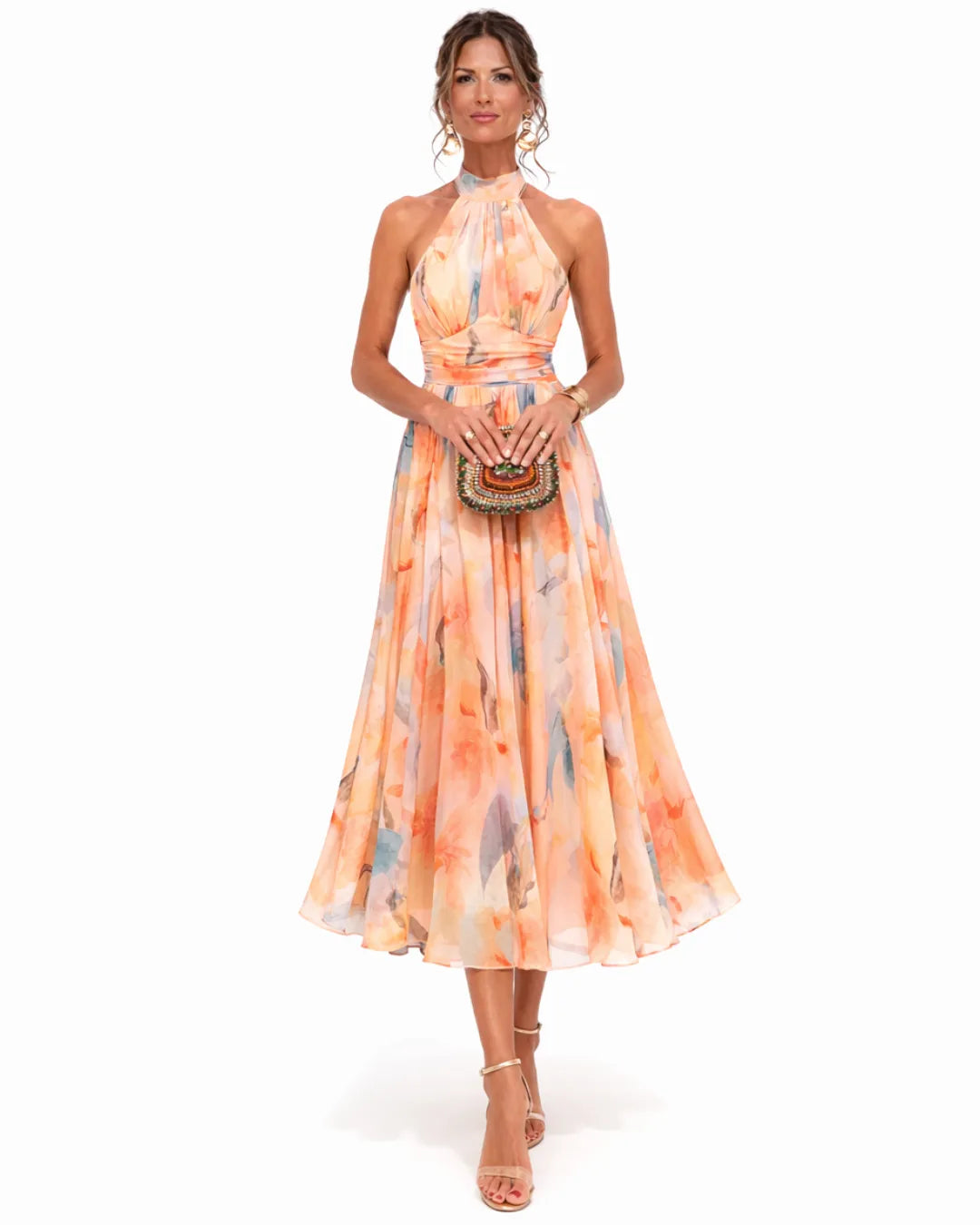 Woman in a peach watercolour floral halter neck midi dress holding a beaded clutch, front view