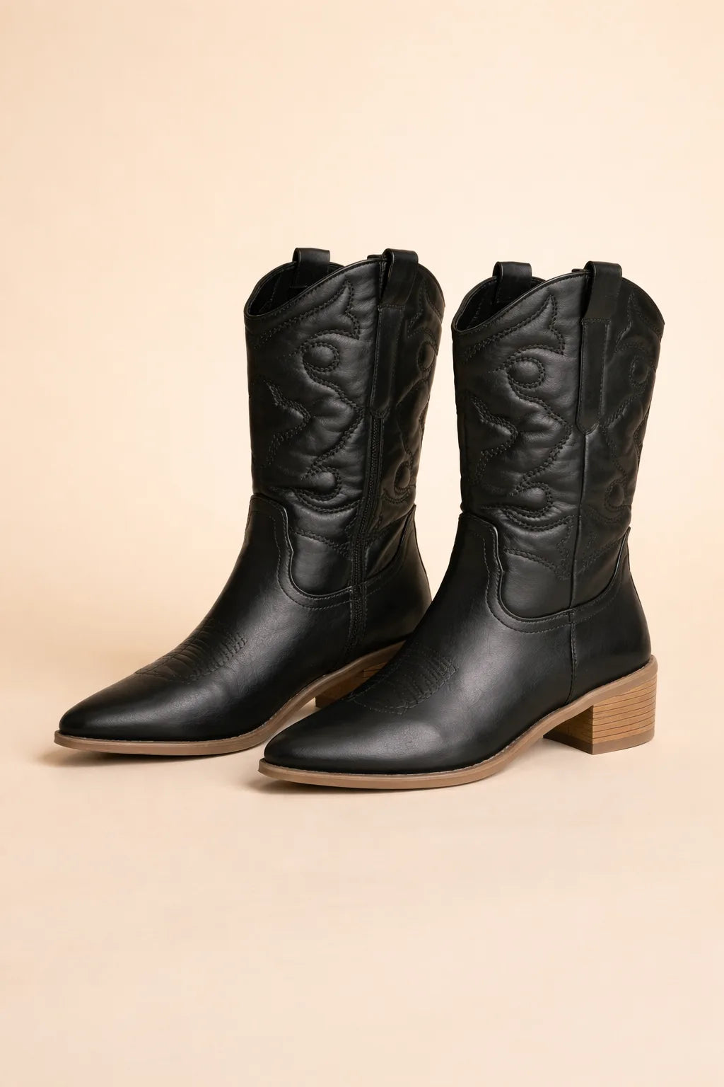 Front pair view of black cowboy boots on a plain background showing stitched shaft and wooden-look heel