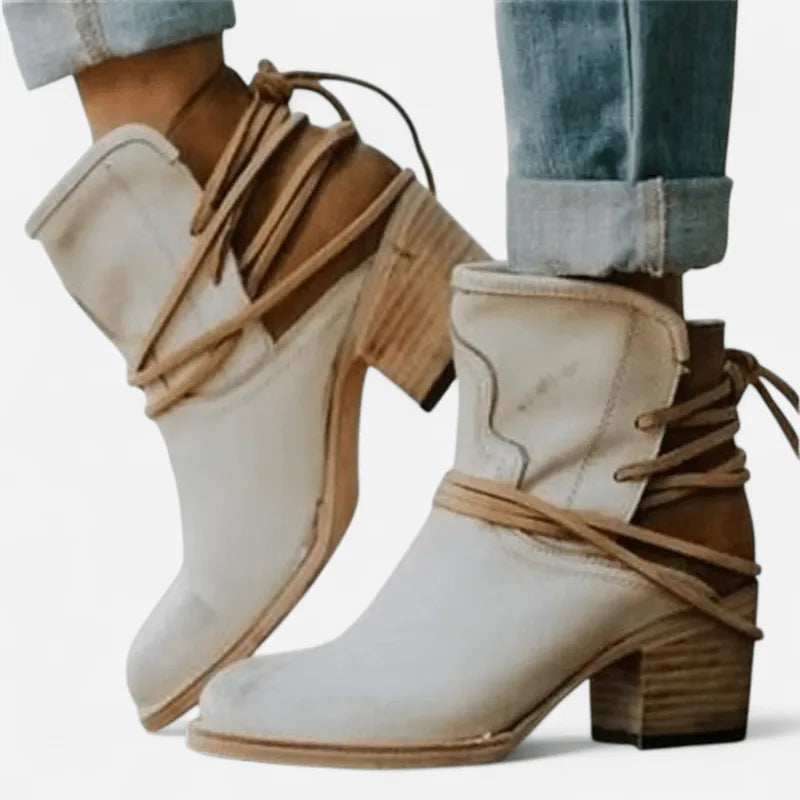 Cream leather western ankle boots with tan suede heel panel and wrap laces, shown on model's feet