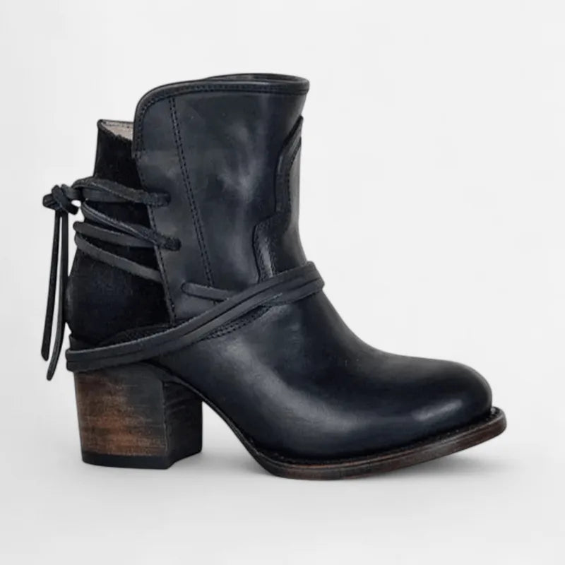 Side view of black leather western ankle boot with suede heel panel and wrap-around lace detail