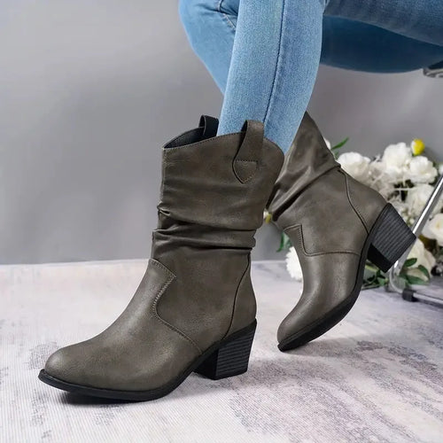 Grey slouch western ankle boots with stacked heel shown against a floral backdrop, pointed toe detail visible