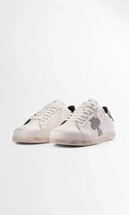 Front three-quarter view of two white leather sneakers highlighting the chunky cream sole and black heel accent.