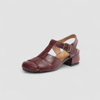 Angled studio shot of burgundy leather sandal showing woven toe straps, slingback and low block heel