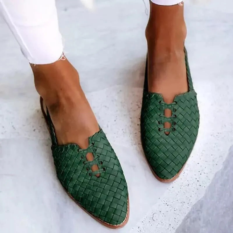 Deep green woven leather flats showing pointed toe shape and crisscross lace detail at the vamp
