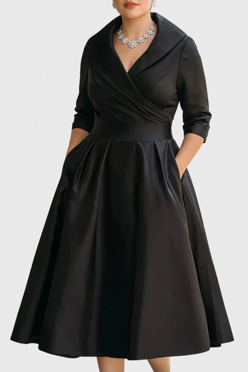 Close-up front view of the wrap midi dress in black satin, highlighting the shawl collar, draped bodice and three-quarter sleeves.